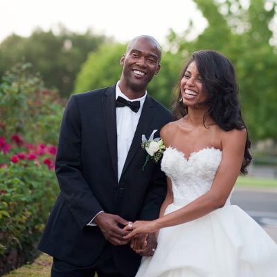 Both are posing on their wedding dress holding hands.
